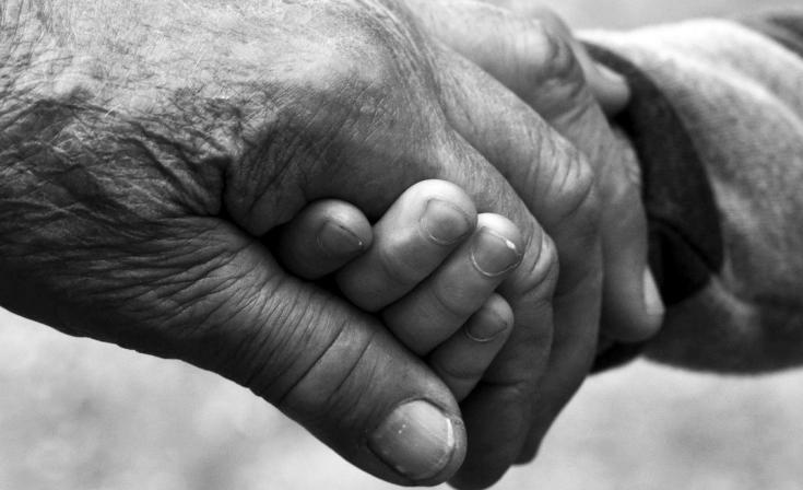 Close up on holding hands - one old and one young hand